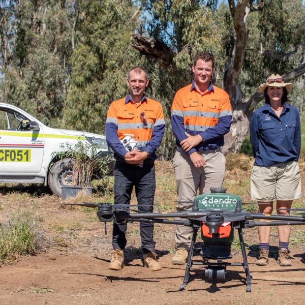 Four people in front of Dendra Systems drone