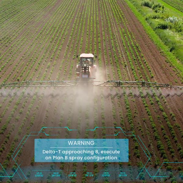 A tractor and spray boom spraying a cotton paddock.